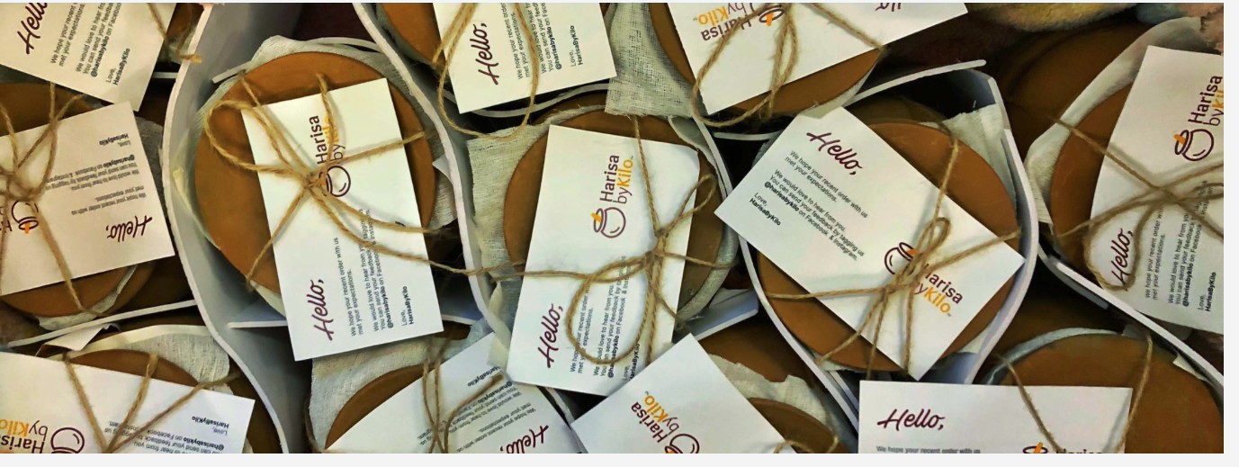 Earthen pots of Harisa byKilo harisa, tied with twine and a handwritten Hello card